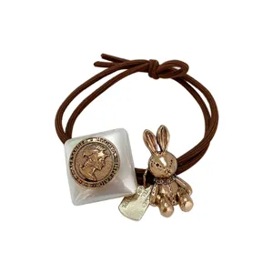 Cute brown hair tie with vintage coin and rabbit charm for women and girls daily wear.