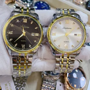 Detailed view of men's two-tone quartz watch featuring Roman numerals, rhinestones, and date display.