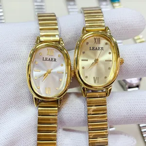 Primer plano detallado de relojes de cuarzo ovalados dorados para mujer con correa de metal elegante.