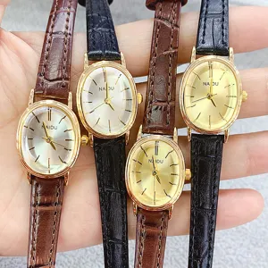 Close-up detail of vintage oval quartz women watches with black and brown leather straps.