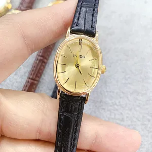 Minimalist oval quartz women watch with gold dial and black leather strap, elegant daily wear.