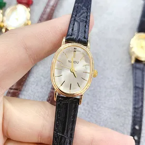 NAIDU women's vintage oval quartz watch with black leather strap and golden case detail.