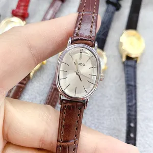 Elegant oval quartz watch with brown leather strap, minimalist dial design for women daily wear.