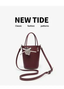 Burgundy leather bucket bag detail featuring a pearl heart charm and elegant ribbon decor.