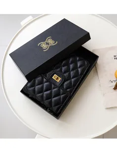 Black quilted leather chain phone bag detail view with gold turn-lock clasp and gift box
