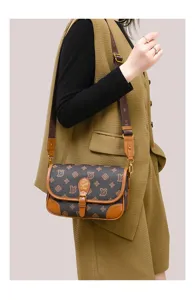 Detailed view of the women brown monogram shoulder crossbody bag with leather trim and gold hardware.