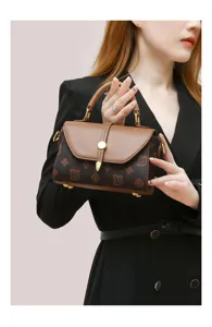 Detailed view of the vintage women handbag with monogram print, metal lock, and top handle.