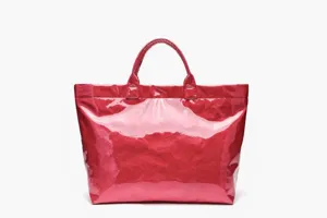 Close-up detail of the glossy red waterproof tote bag, showcasing durable reinforced handles.