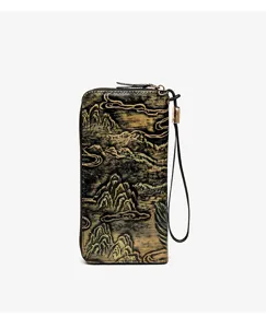 Detail view of retro embossed landscape long wallet with zipper closure and practical wrist strap.