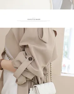 Close-up detail of stylish beige trench coat and elegant quilted chain mini bag.