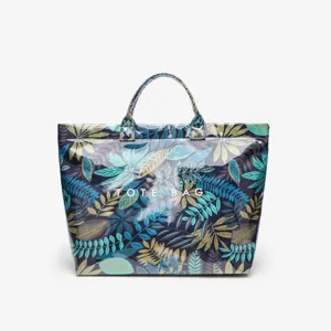 Detailed view of the waterproof tote bag featuring a stylish leaf pattern and sturdy handles.