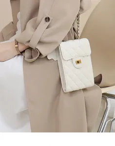 Close up of white quilted mini phone bag with chain strap and chic turn lock detail.