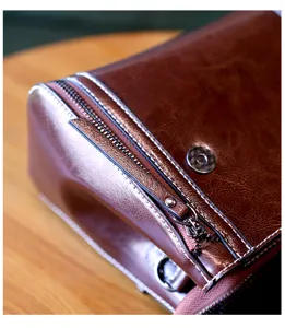 Detailed close-up of retro brown leather crossbody bag with neat stitching and metal zipper.