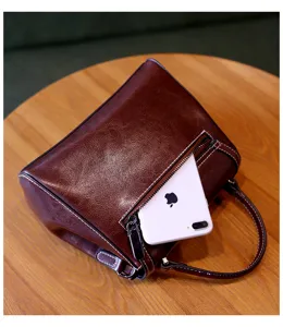Brown vintage leather handbag detail showing zipper pocket and spacious interior capacity