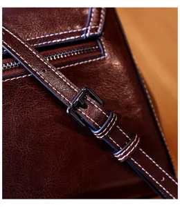 Detailed close-up view of vintage brown leather crossbody bag strap and hardware details.