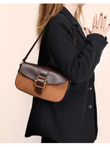 Nahaufnahme Detailansicht einer Wildleder und Leder Schultertasche mit metallischer Schließe.