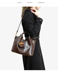 Close-up detail of the brown leather bucket bag, showing premium texture and shoulder strap.