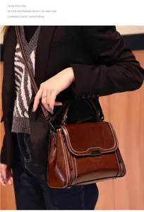 Detailed view of dark brown leather crossbody bag with metal lock and shoulder strap.