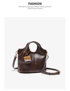 Brown leather bucket bag detail view featuring chic chain charm and adjustable strap style.