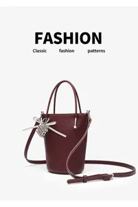 Minimalist burgundy leather bucket bag with cute bow charm, chic mini crossbody bag for women.