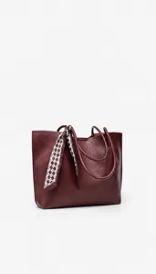 Details of the large capacity burgundy leather tote bag with stylish scarf handle decoration.