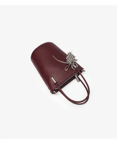 Mini burgundy leather bucket bag with silver metal bow charm, stylish niche design handbag.