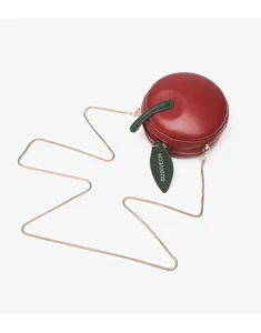 Detail view of a stylish red apple shaped round crossbody bag with a chic gold chain strap.