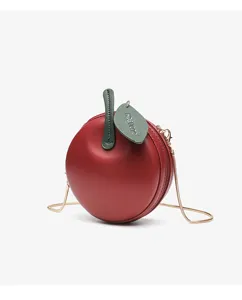 Red apple shaped round crossbody bag with green leaf and gold chain strap, stylish design.