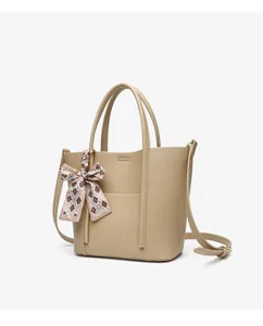 Close-up detail of the stylish genuine leather handbag featuring a chic plaid bow ribbon.