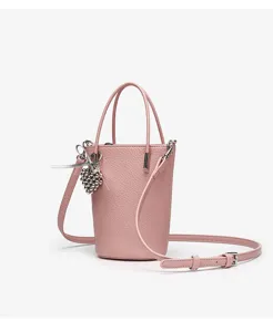 Pink mini bucket bag detail showcasing textured leather surface, metal hardware and cute pendant.