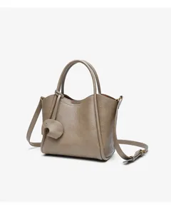 Detailed view of the elegant grey leather handbag featuring top handles and a shoulder strap.