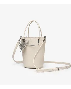 Mini leather bucket bag detail in beige, featuring pebble texture and a chic silver bead charm.