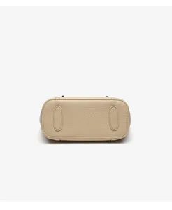 Close-up view of the beige leather handbag bottom, showing fine texture and durable design details.