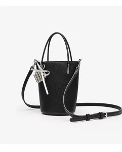 Detailed view of the black textured mini bucket bag with chic silver bow charm and shoulder strap.