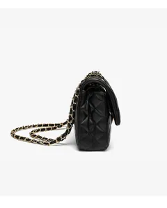 Side detail view of black quilted leather crossbody shoulder bag with gold chain strap craftsmanship.