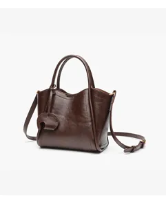 Brown leather handbag detail, premium commuter crossbody bag with double handles and metal hardware.