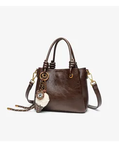 Detailed view of the vintage brown leather handbag featuring stylish knots and a cute pendant.