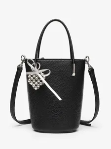 Black pebbled leather bucket bag with top handle, crossbody strap and cute heart charm.
