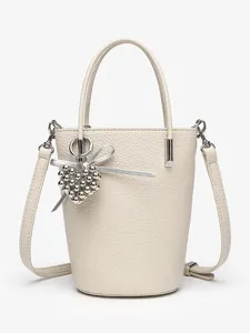 Chic beige leather bucket bag with silver heart charm and crossbody strap for women.