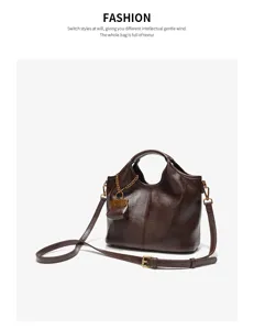 Brown leather shoulder bag detail, soft texture, elegant handle and cute mini pouch charm.