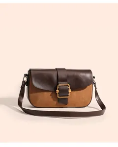 Detailansicht der braunen Schultertasche, Wildleder und Leder-Textur mit Metallschnalle.