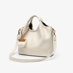 Detailed closeup view of white leather bucket bag texture, exquisite metal hardware & pouch.
