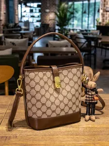 Elegant monogram bucket bag with top handle and crossbody strap for women daily fashion use.