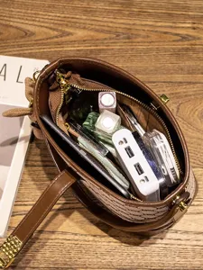 Stylish brown printed bucket bag with large capacity, chic handle and crossbody strap for women.