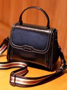 Black leather top handle shoulder bag with striped webbing strap, retro style for daily use.