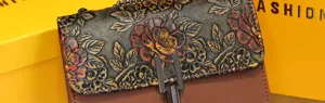 Detailed view of vintage embossed leather crossbody bag with floral pattern and metal lock.