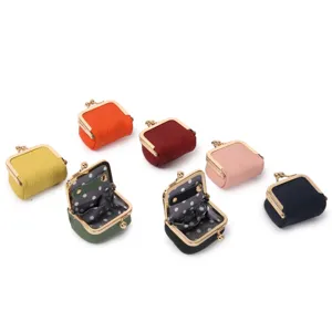 Mini leather kiss-lock coin purse detail, compact jewelry box for rings and earrings securely.