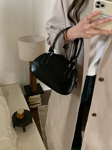 Black patent leather bowling bag, stylish top-handle handbag for women, chic daily accessory.