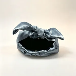 Detailed view of the stylish metallic finish knot handbag showing the unique rabbit ear handle.