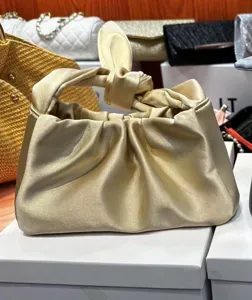 Gold satin knotted handbag with cute bunny ear handle design, chic evening purse for women.